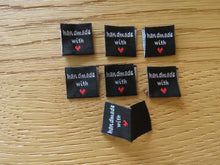 Load image into Gallery viewer, 10 Black Handmade with red heart 2 x 2cm satin flag labels.