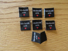 Load image into Gallery viewer, 25 Black Handmade with red heart 2 x 2cm satin flag labels.